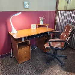 An empty desk with an office chair in front of it